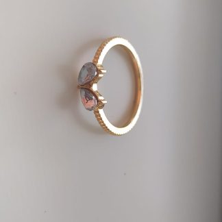 Anillo dorado con dos piedras lila y rosa engarzadas