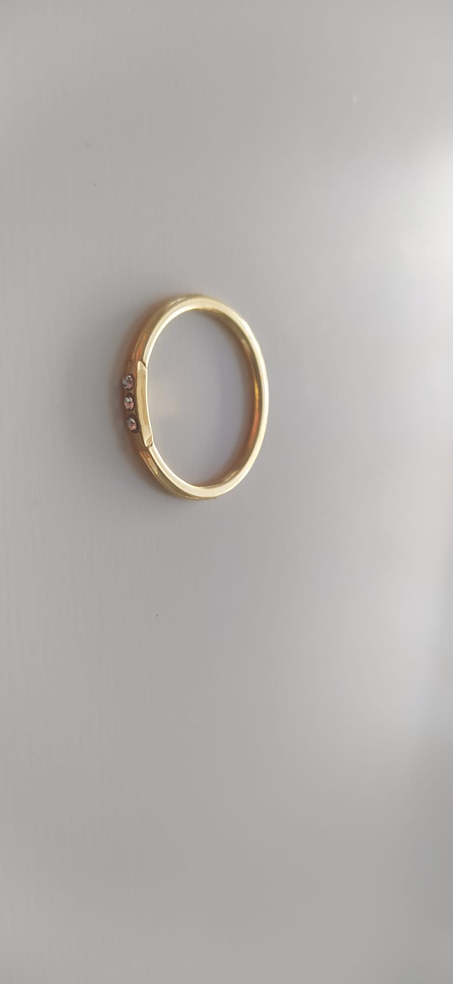 Anillo dorado fino con tres circonitas engastadas