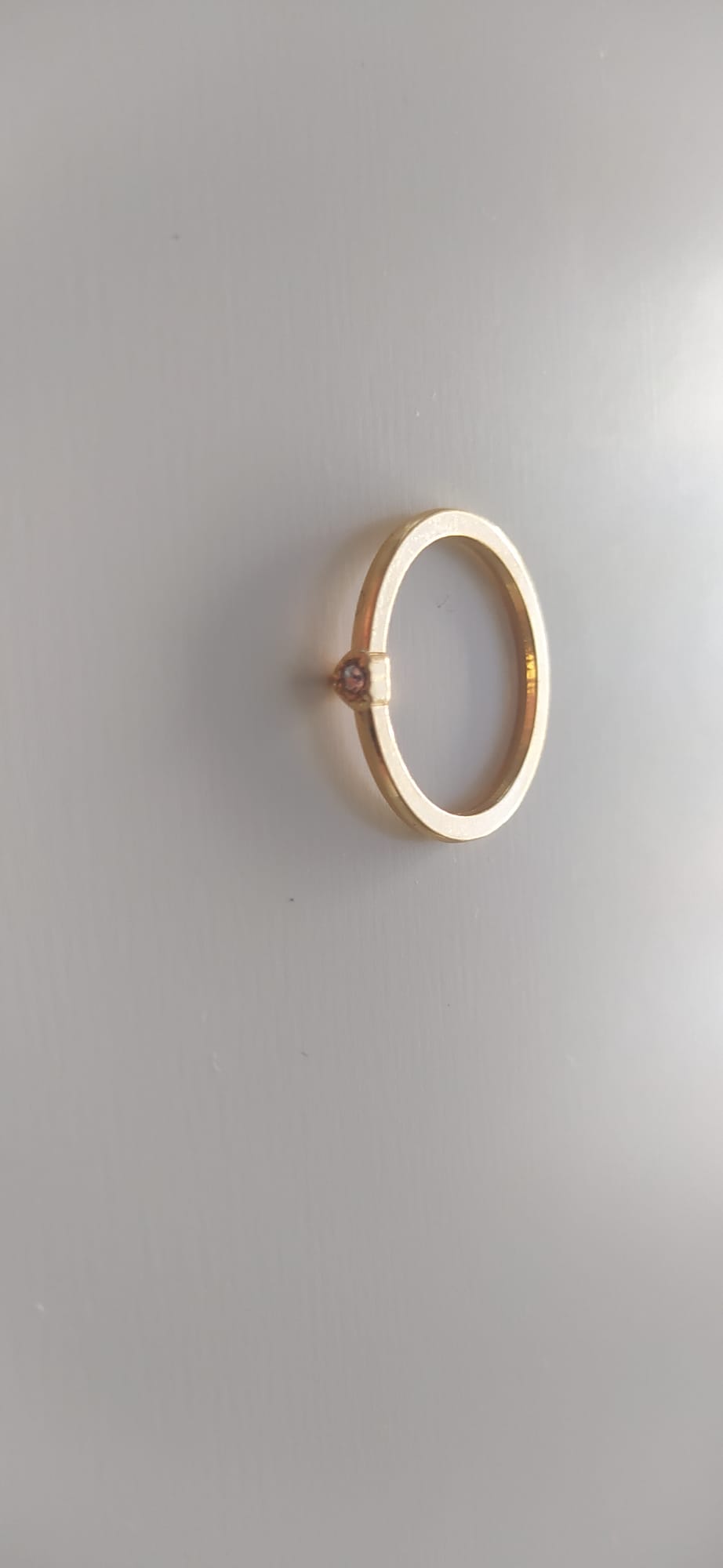 Anillo dorado liso con pequeña circonita engastada