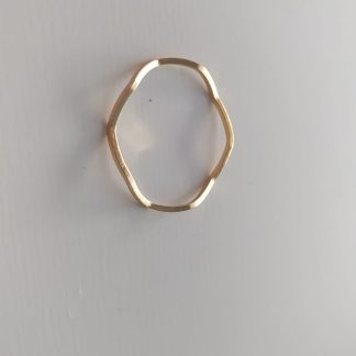 Anillo dorado ondulado de líneas irregulares sobre fondo claro