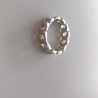 Anillo plateado ancho con textura de eslabones de cadena entrelazados