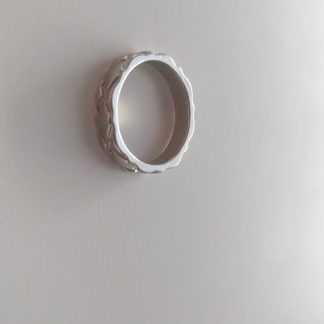 Anillo plateado ancho de bisutería con relieve de X entrelazadas