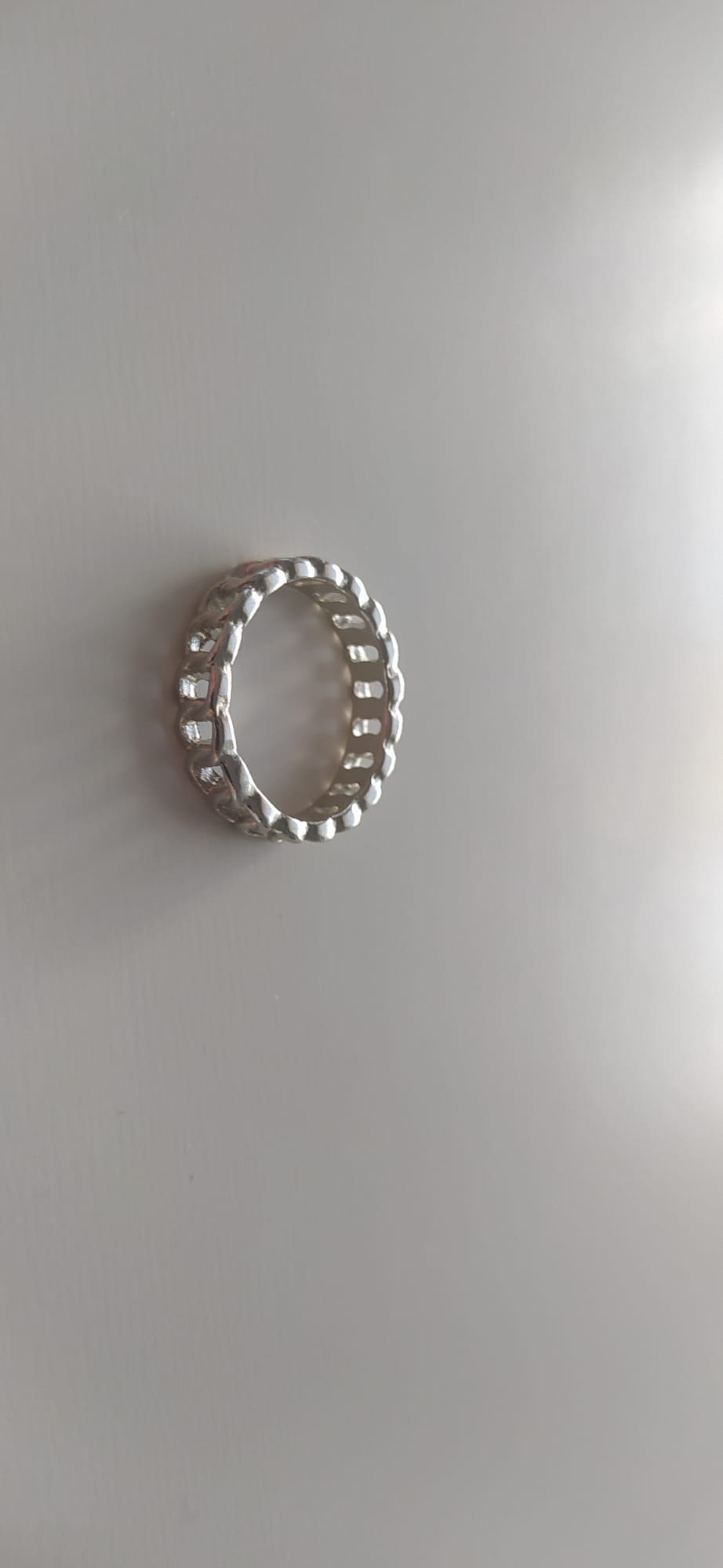 Anillo plateado de bisutería con textura de cadena eslabonada