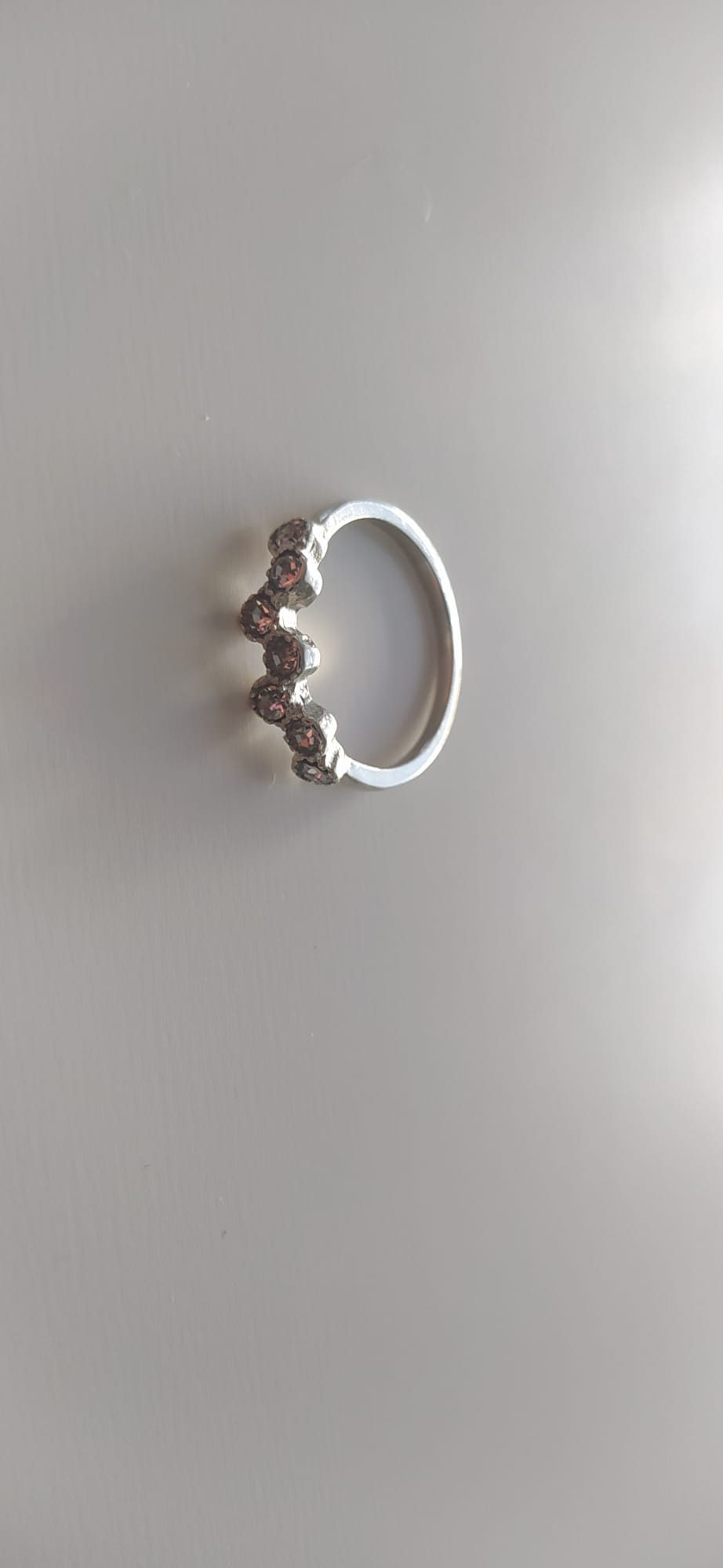Anillo plateado de bisutería con fila de circonitas rosas estilo tiara