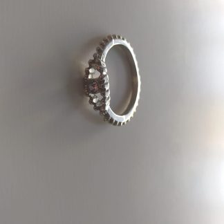 Anillo plateado de bisutería con flor de circonitas rosas
