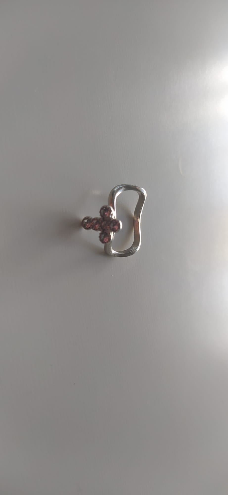 Anillo plateado ondulado de bisutería con cruz de circonitas rosas