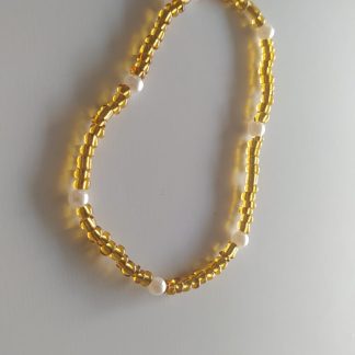 Collar dorado de abalorios tubulares con perlas blancas