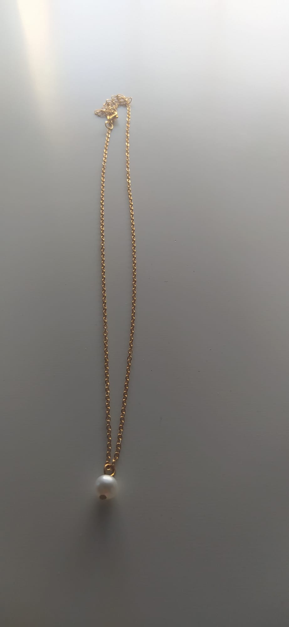 Collar dorado fino con colgante de una perla blanca