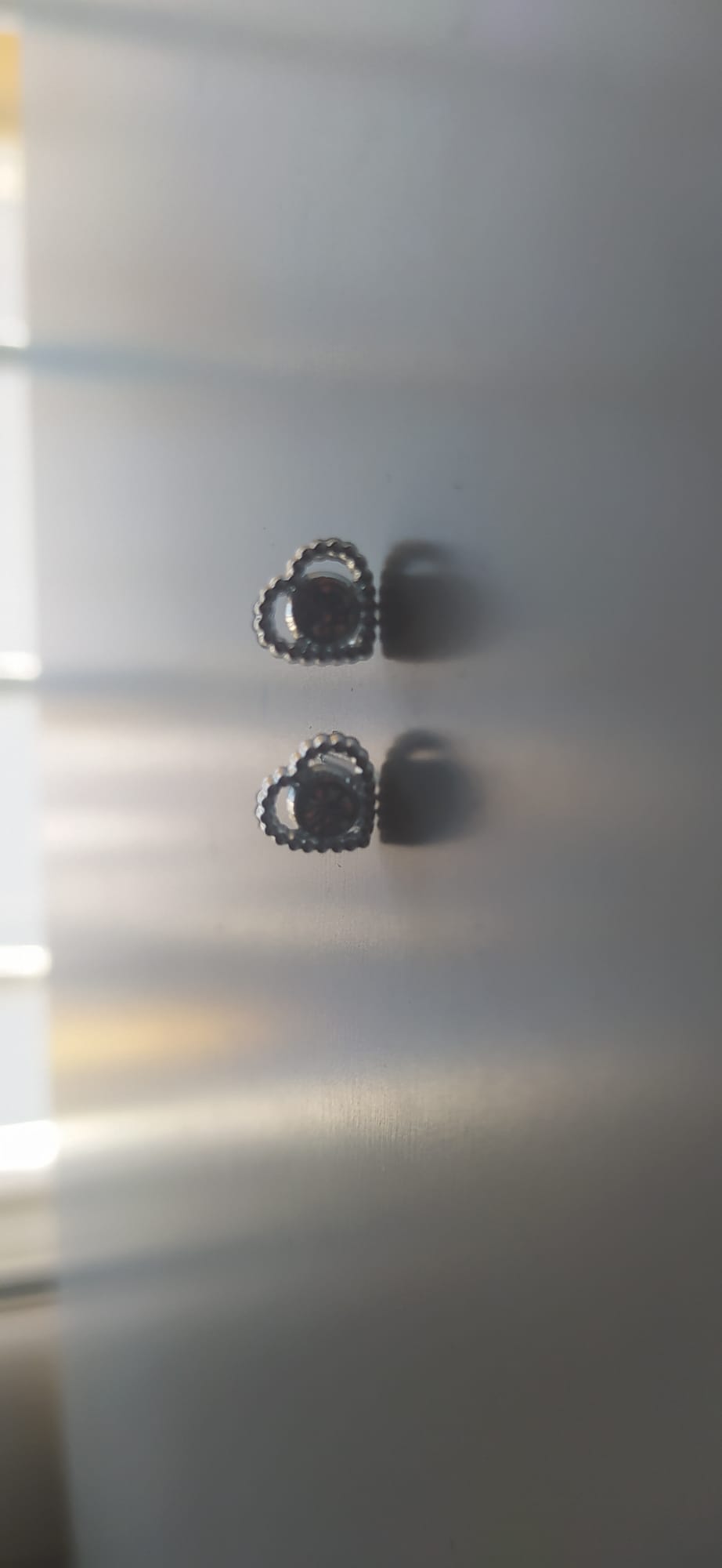 Pendientes de corazón plateado con borde texturizado y piedra marrón