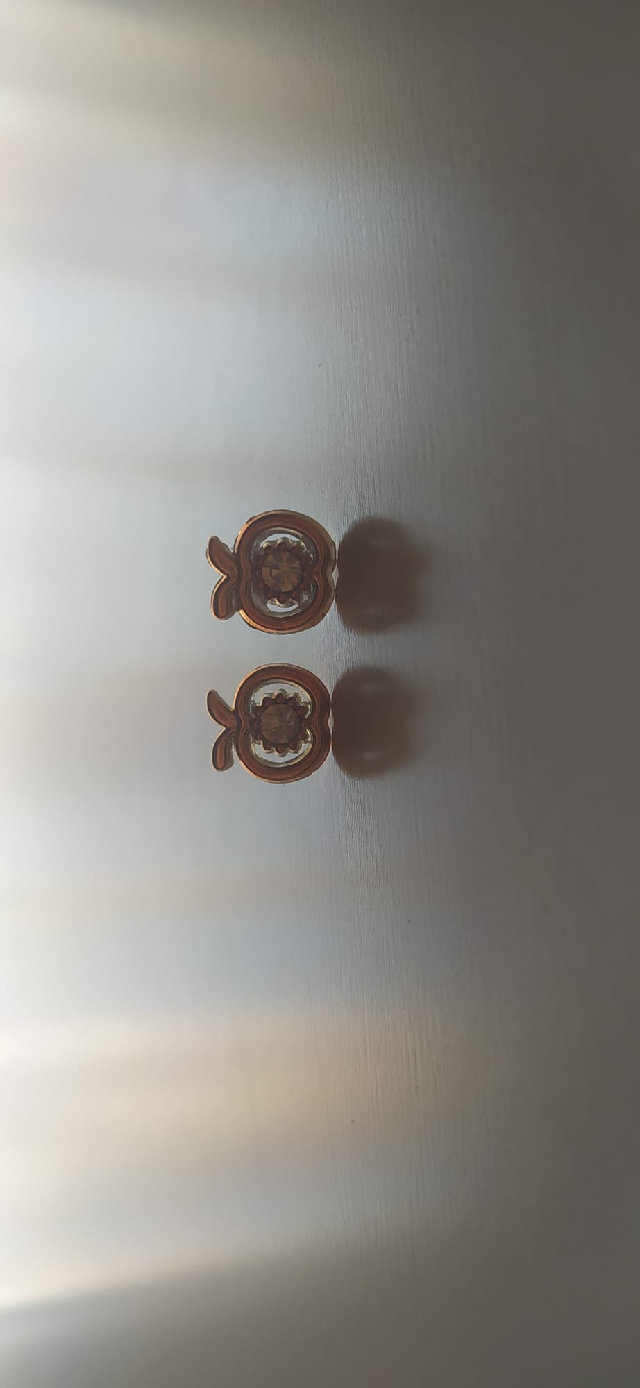 Pendientes dorados con circonita central y detalle de lazo