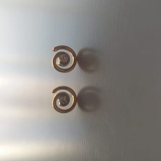Pendientes dorados en espiral con piedra brillante en el centro