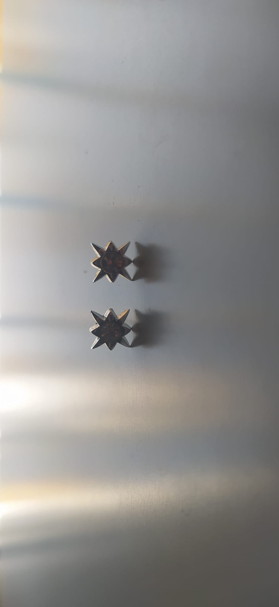 Pendientes plateados de estrella con piedra central granate