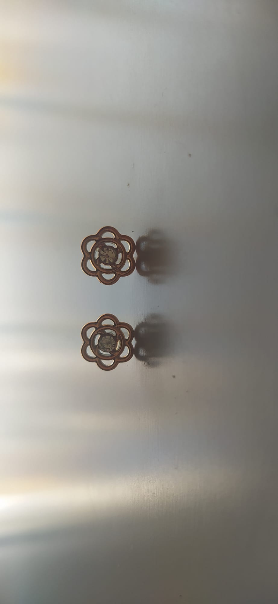 Pendientes dorados en forma de flor con circonita central
