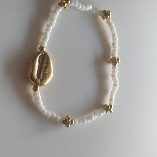 Pulsera blanca con colgante de concha dorada y flores doradas