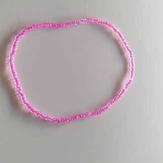 Pulsera de abalorios dorados brillantes sobre superficie clara
