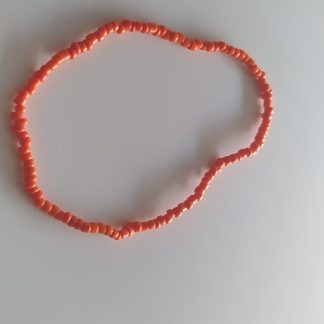 Pulsera artesanal de cuentas naranja coral sobre superficie clara