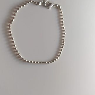 Pulsera de bolitas plateadas con cierre de mosquetón sobre fondo claro