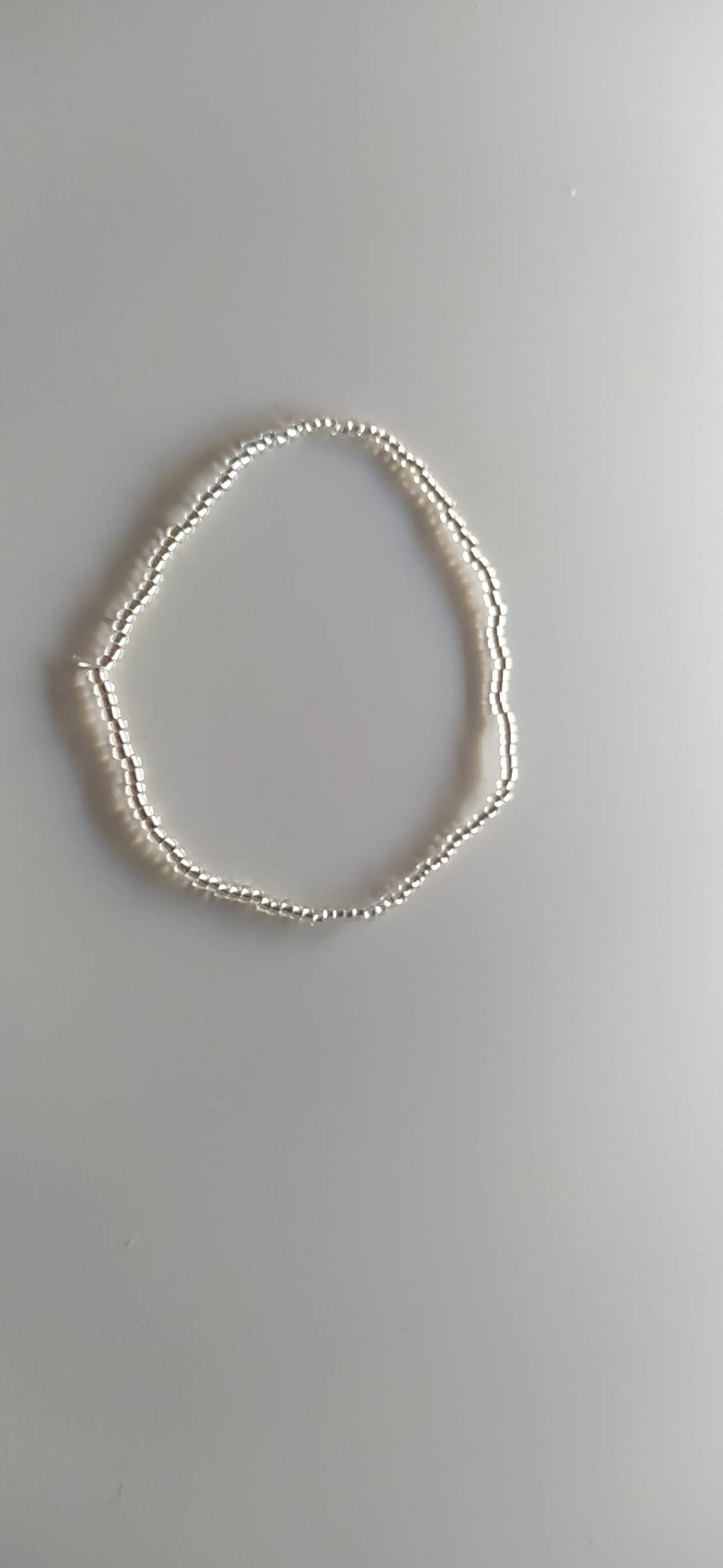 Pulsera artesanal de doble hebra con cuentas plateadas brillantes