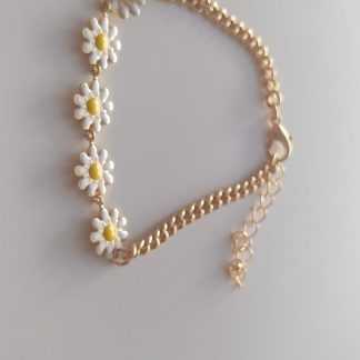 Pulsera dorada con flores de margarita blancas y amarillas