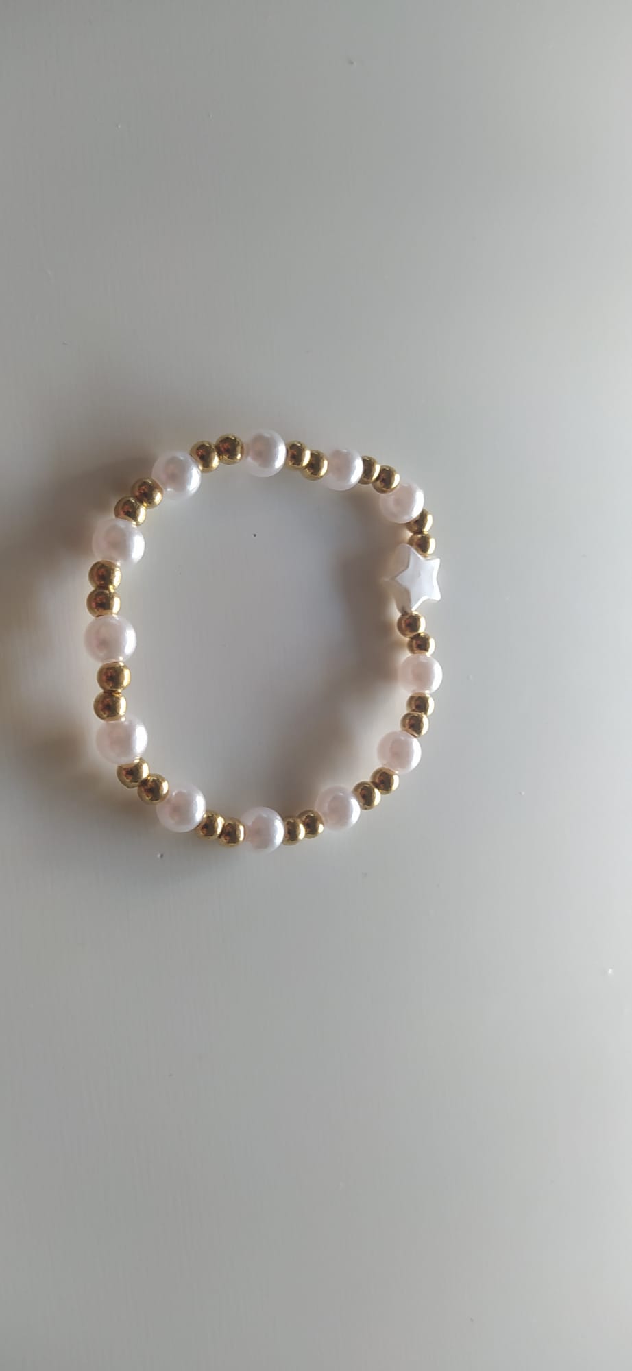 Pulsera de perlas blancas con charm de estrella y bolitas doradas